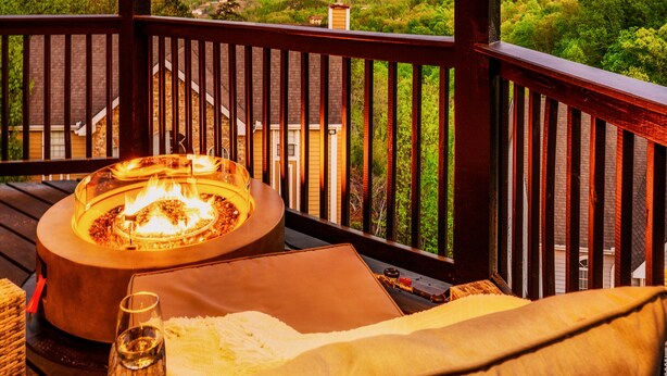Una terraza con un hoyo de fuego, asientos y vistas a las montañas.