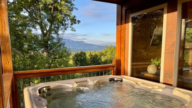 A hot tub on a wooden deck with a view of mountains and trees. - Brand New Chalet With Spectacular Views- Ursa Mons (Gatlinburg)