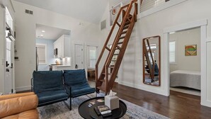 Un salon moderne avec un canapé, une table basse et un escalier en bois.