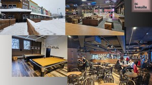 A billiards room with a pool table, a bar area with seating, and a view of a snowy street outside. - Ameno 3, Himos by DG Lomailu - skiing, skiing, golf, padel and events (Jämsä)