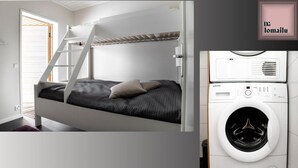 A bunk bed with a ladder, a washing machine, and a door with a sign. - Ameno 1, Himos by DG Lomailu - skiing, skiing, golf, padel and events (Jämsä)