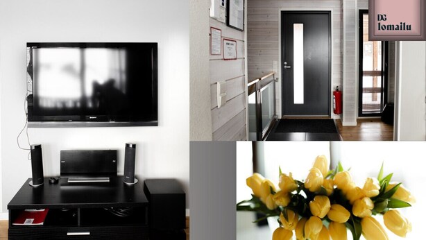 A modern hotel room with a flat-screen TV, a black entertainment unit, a wooden door, and a framed sign on the wall. - Ameno 1, Himos by DG Lomailu - skiing, skiing, golf, padel and events (Jämsä)