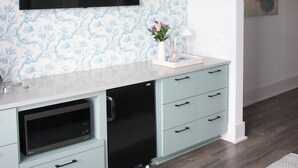 Eine moderne Küche mit Einbauofen, einem schwarzen Kühlschrank und einem hellblauen Schrank.