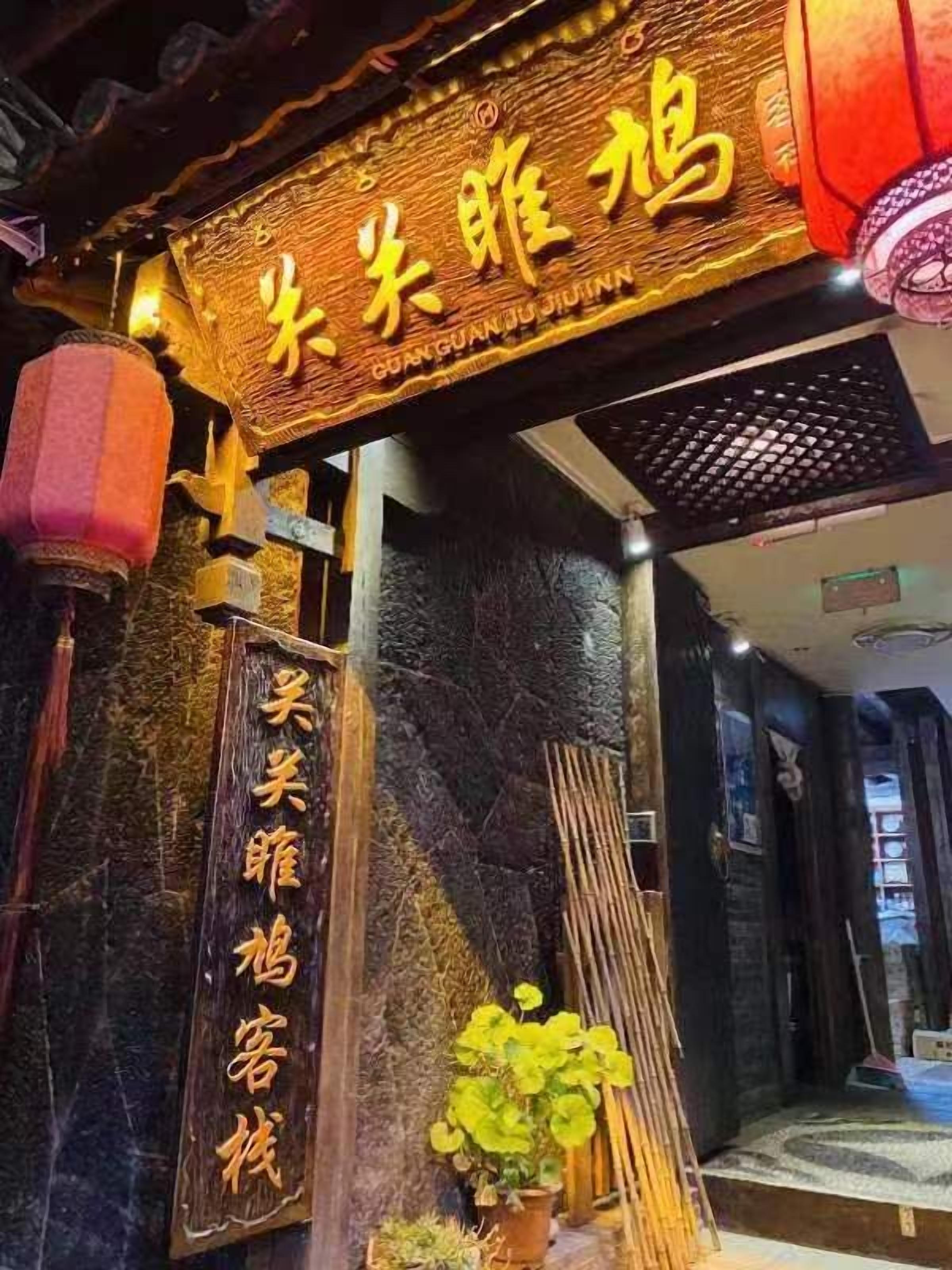 A traditional Chinese restaurant entrance with a signboard and a wooden door.