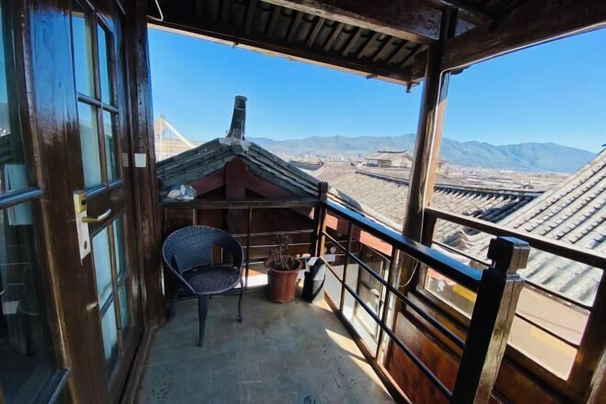A balcony with a view of a cityscape and mountains.