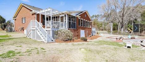 A two-story house with a covered porch and a fenced yard.