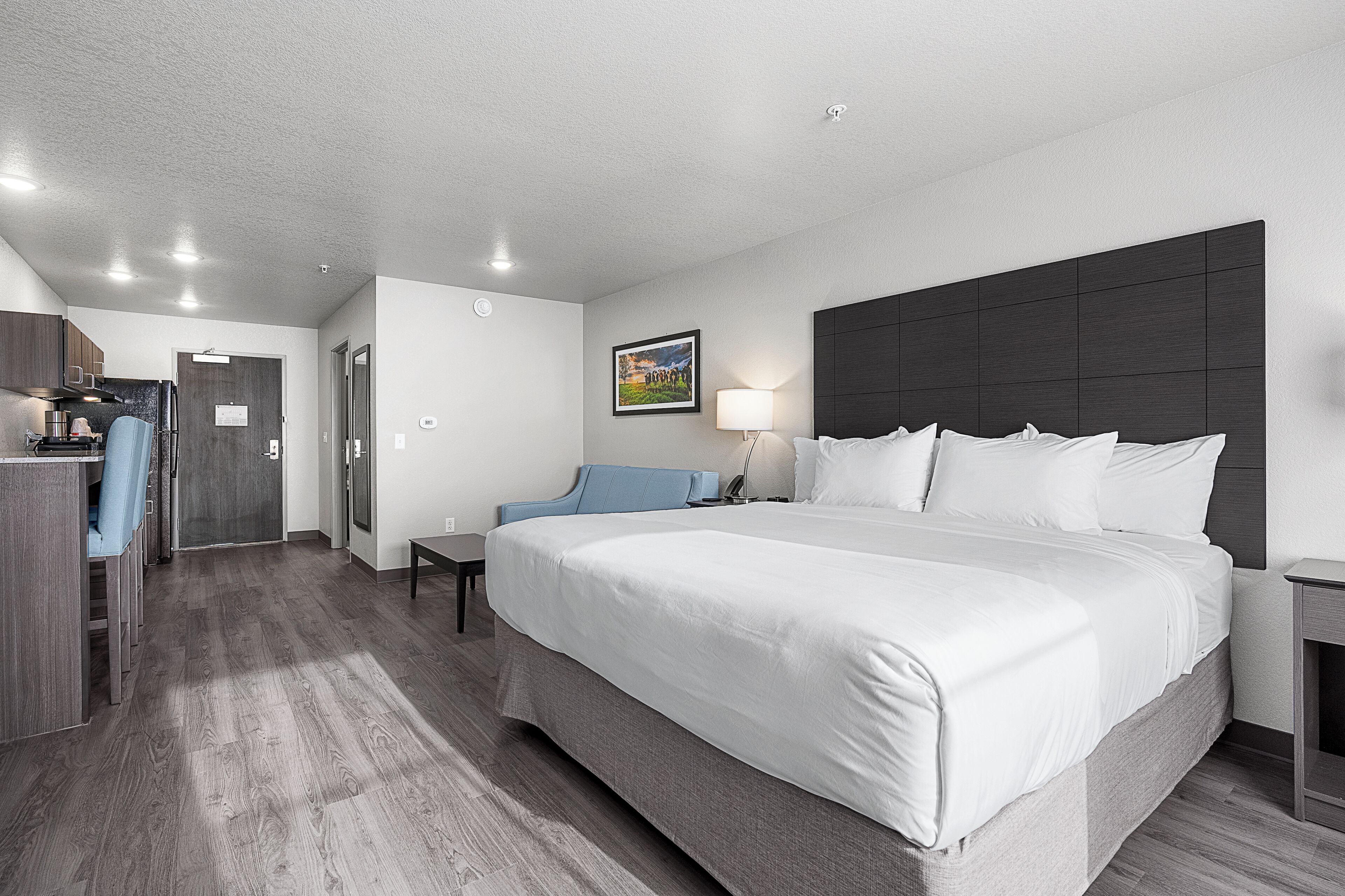 Een hotelkamer met een groot bed, een bureau en een stoel.