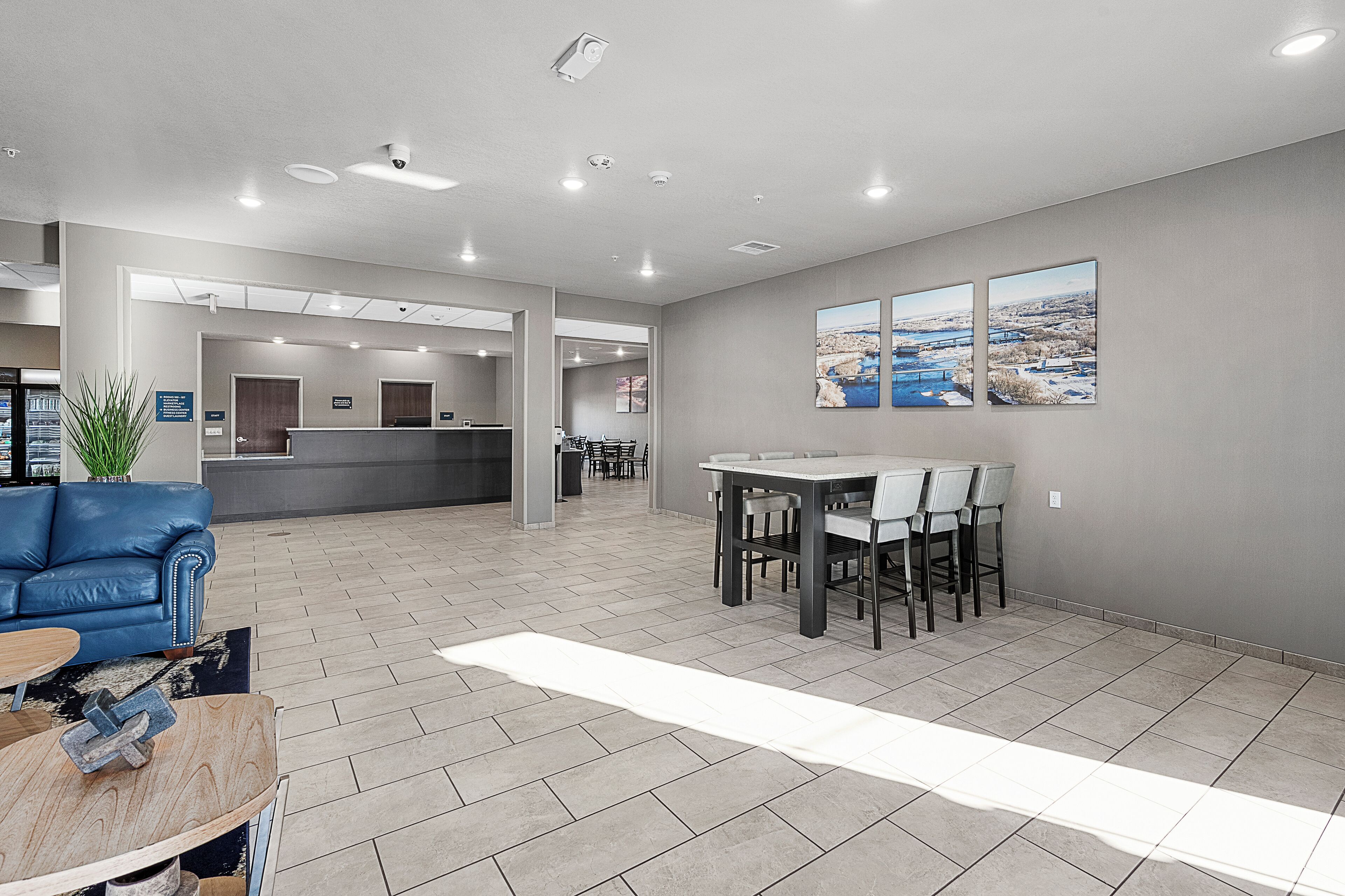 Eine geräumige Lobby mit einer Rezeption, einer Sitzecke und einem großen Fenster mit Blick auf die Stadt.