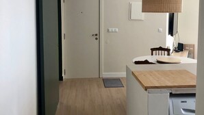 Eine moderne Küche mit Waschmaschine, einer Holzarbeitsplatte und einer Pendelleuchte.