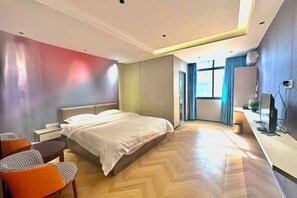 A modern hotel room with a bed, seating area, and a TV. - Nanning Donglian Hotel (Guangxi Police School Xianhe Campus Shop) (Nanning)