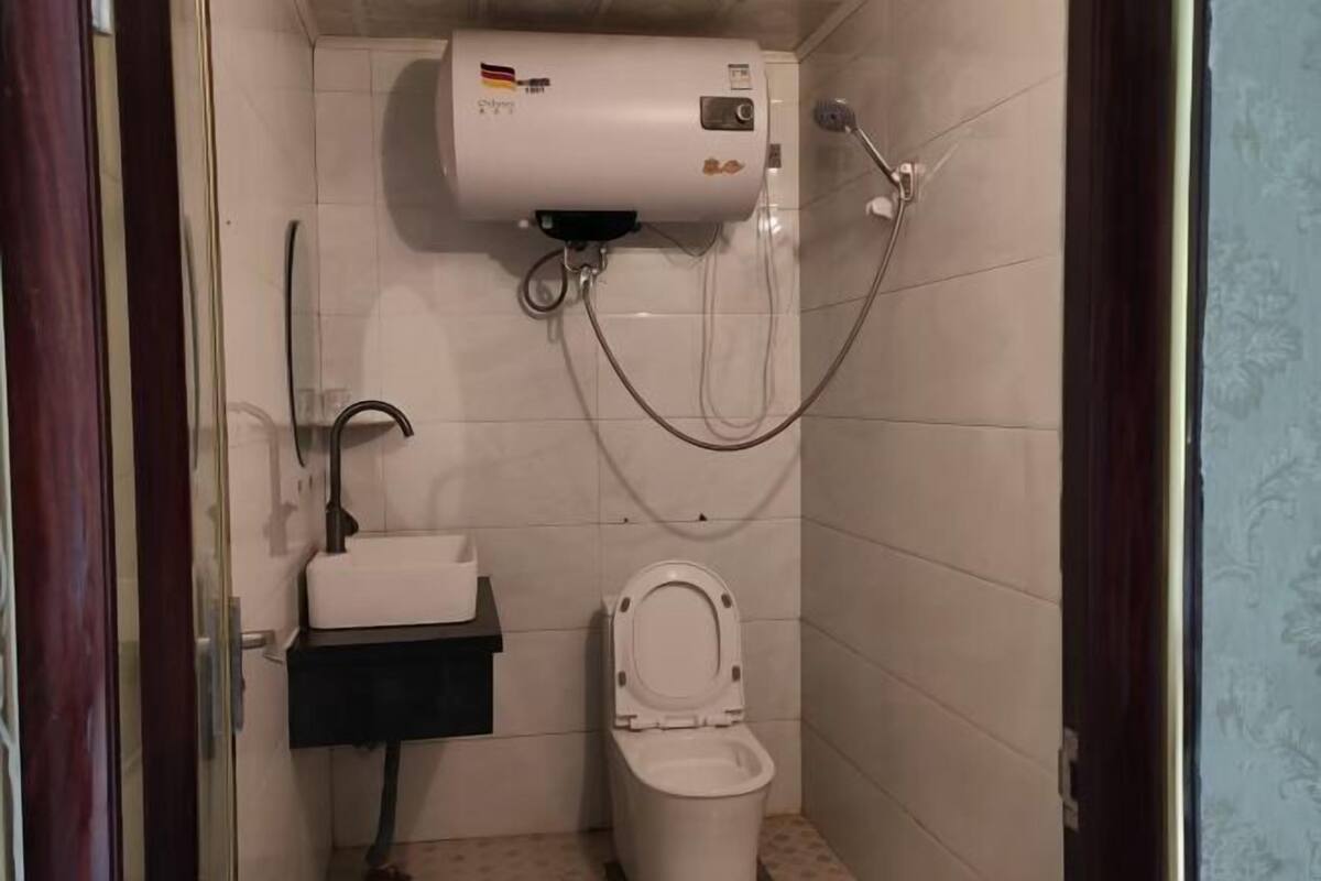 A bathroom with a toilet, sink, and a water heater.