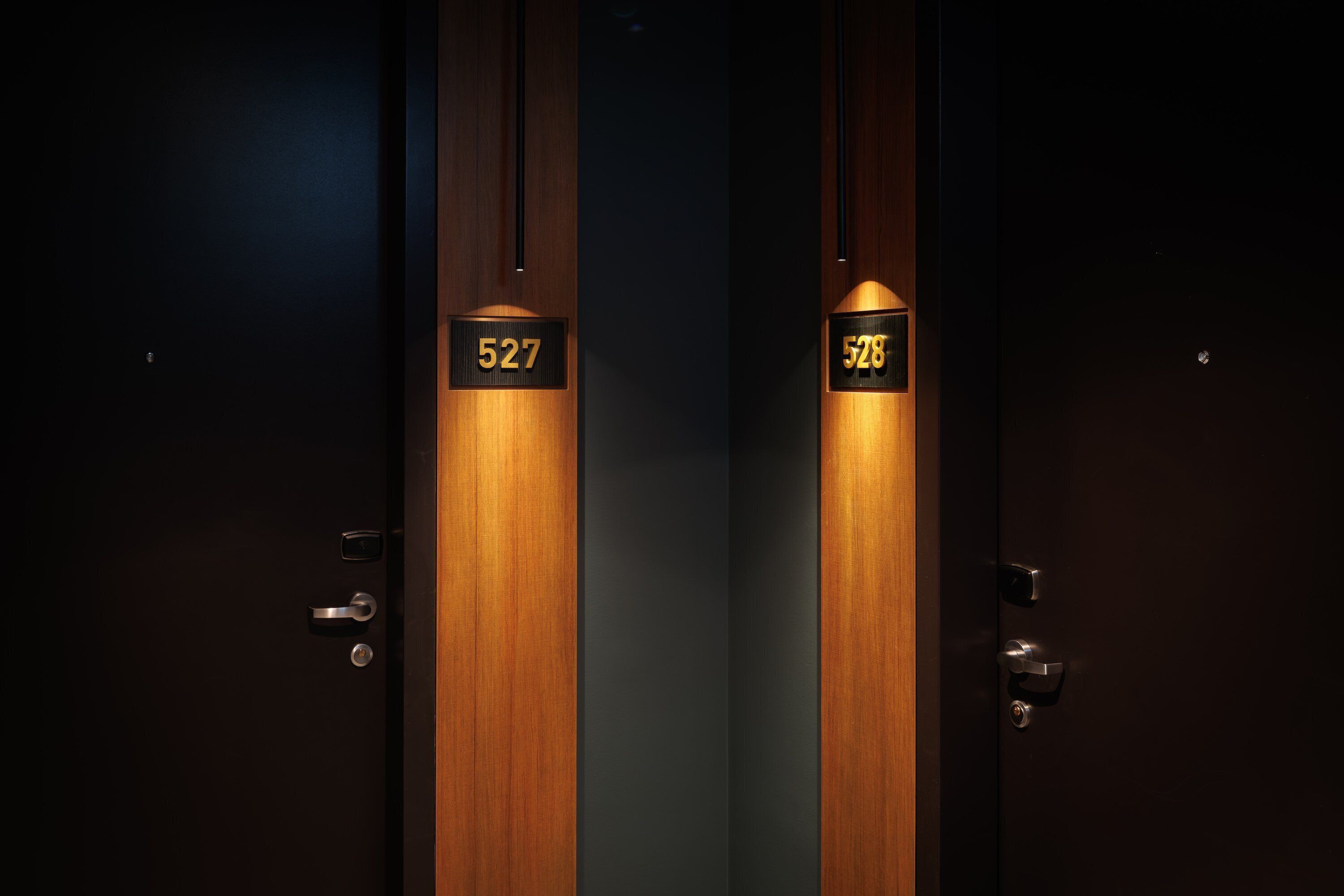 Deux portes portant les numéros 527 et 528, indiquant les numéros des chambres d’hôtel.