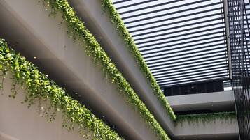 Un edificio moderno con jardines verticales en las paredes exteriores y un diseño de techo con listones.