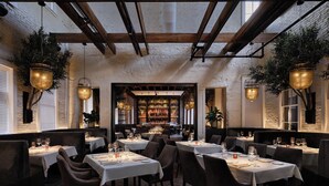 A restaurant with tables set for dining, wooden beams on the ceiling, and hanging plants. - Kimpton Santo San Antonio - Riverwalk by IHG (San Antonio)