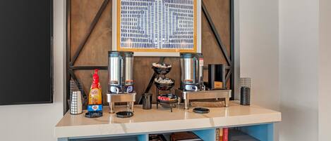 A kitchenette with a coffee maker, toaster, and various condiments.