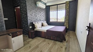 A bedroom with a bed, a desk, and a wardrobe. - OSHO Villa Homestay, 5 minutes to the Jaipur Airport, Garden View AC Rooms,  (Jaipur)