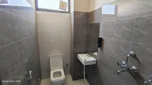 A small, tiled bathroom with a toilet, a sink, and a shower. - OSHO Villa Homestay, 5 minutes to the Jaipur Airport, Garden View AC Rooms,  (Jaipur)