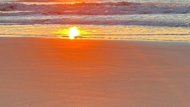 A beach with the sun setting over the ocean. - Myrtle Beach Condo in Kingston Property steps away from Ocean, pool, food & fun (Myrtle Beach)