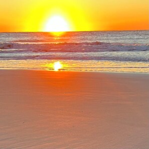 En strand med solnedgang over havet.