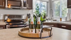 Una cocina con una bandeja de madera que contiene dos botellas de vino espumoso Martini.