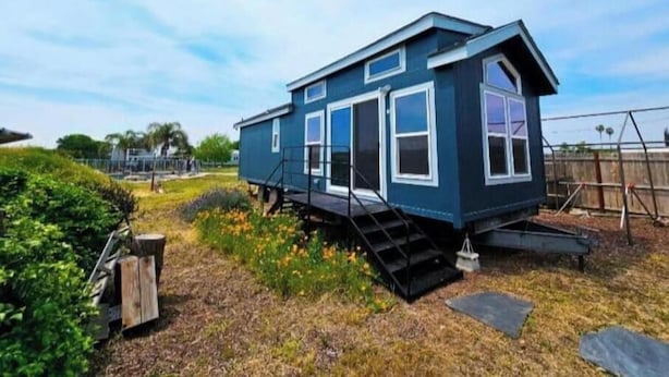 A small, two-story house with a steep staircase leading to the entrance. - Modern Tiny Home Near Sequoia National Park (Lindsay)