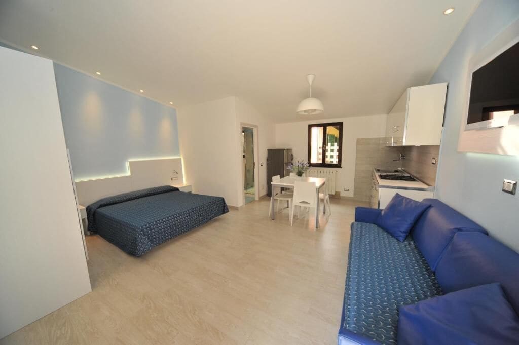 Un espace de vie compact comprenant un lit, un coin repas et une kitchenette.