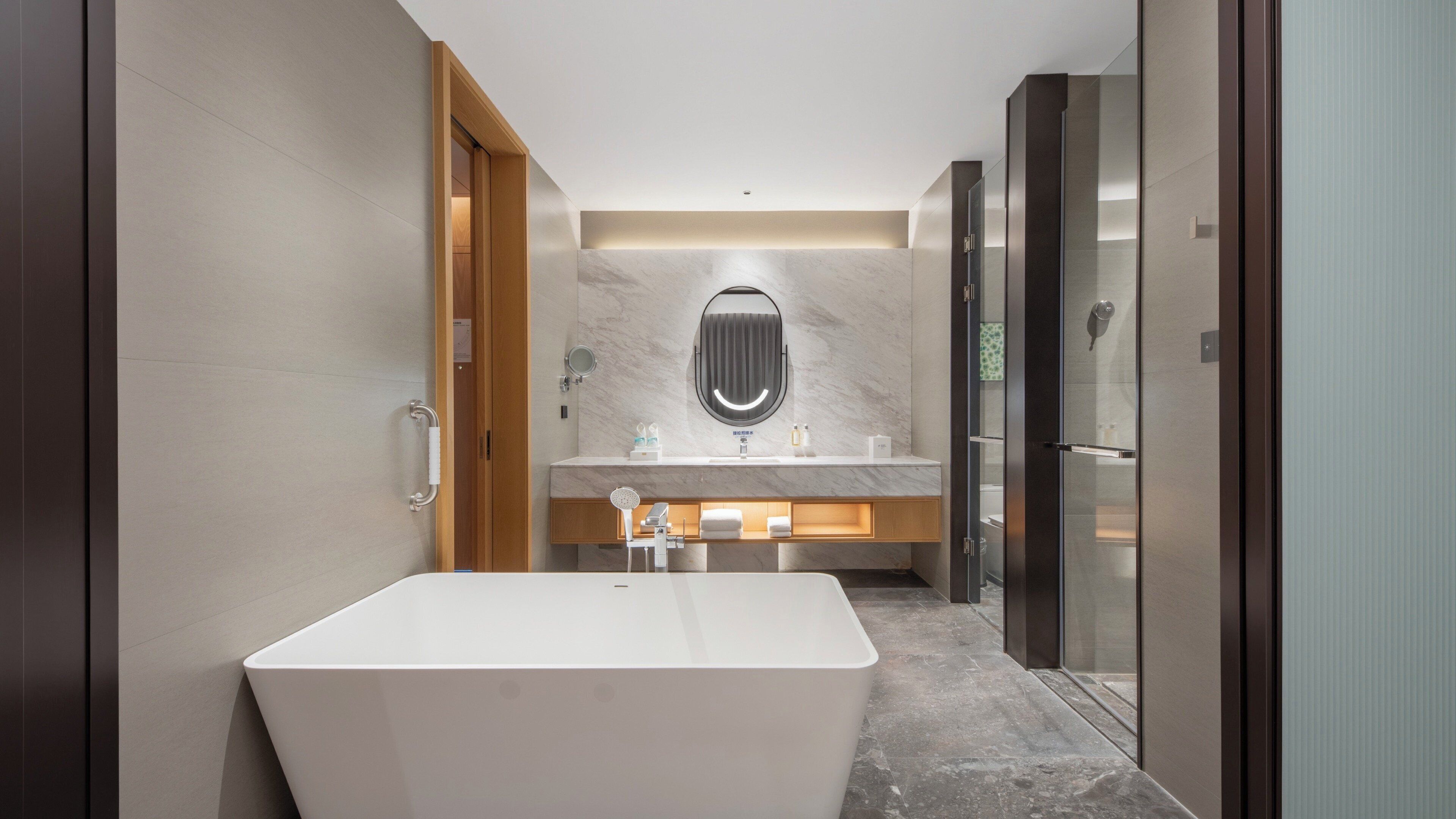 A modern bathroom with a freestanding bathtub, a vanity with a mirror, and a glass shower enclosure.