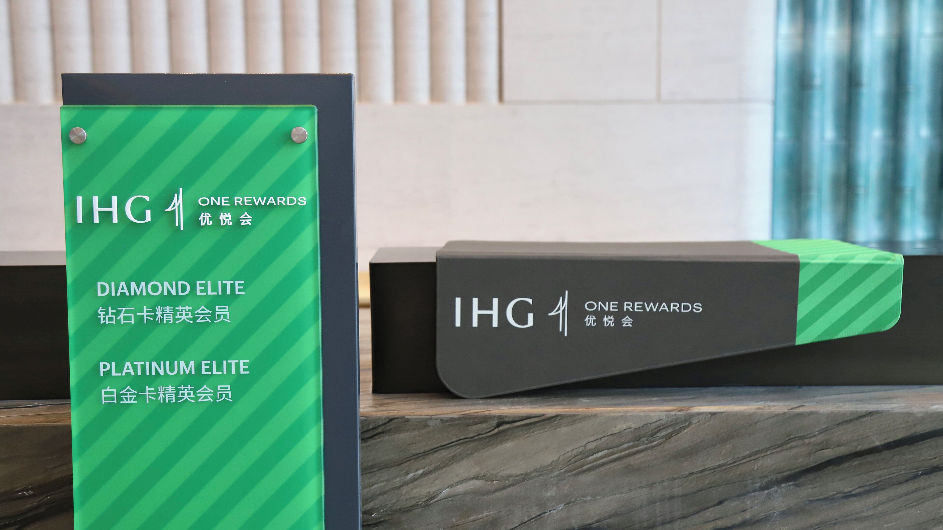 A reception desk with a sign indicating IHG ONE REWARDS Diamond and Platinum Elite membership levels.
