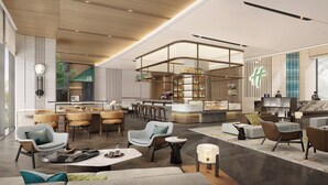 Un moderno vestíbulo de hotel con zona de bar, asientos y mostrador de recepción.