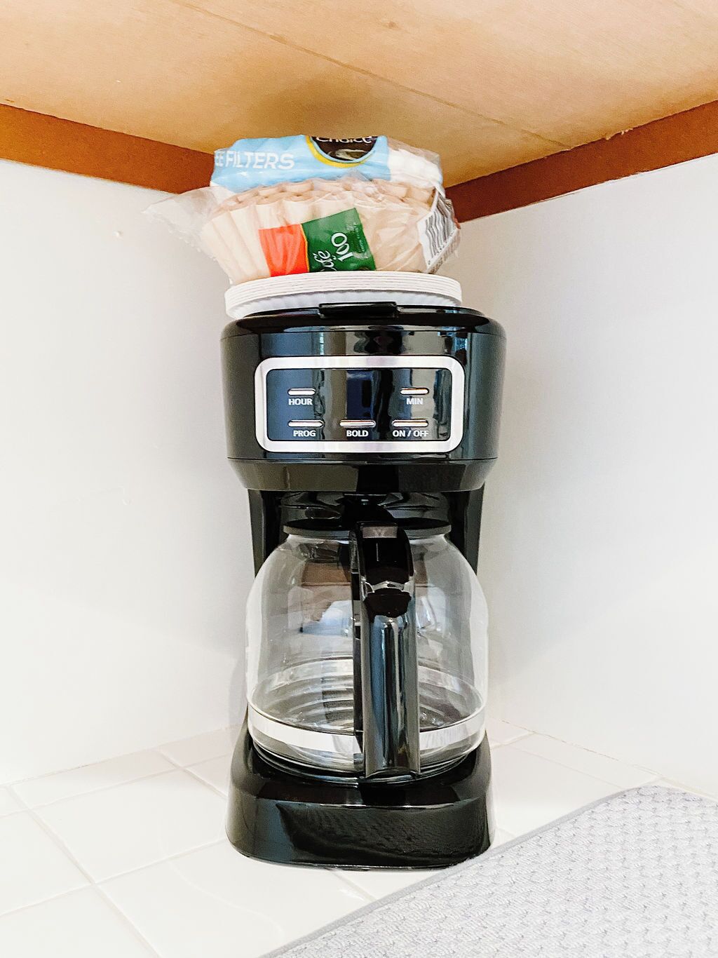 Une machine à café avec un paquet de filtres posé sur le dessus.