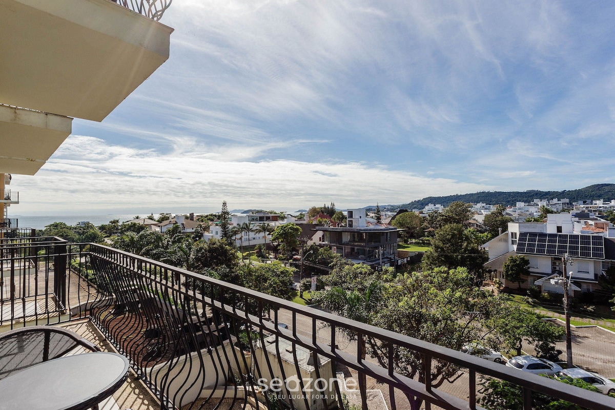 Un balcón con vista a una zona residencial, con casas y árboles.