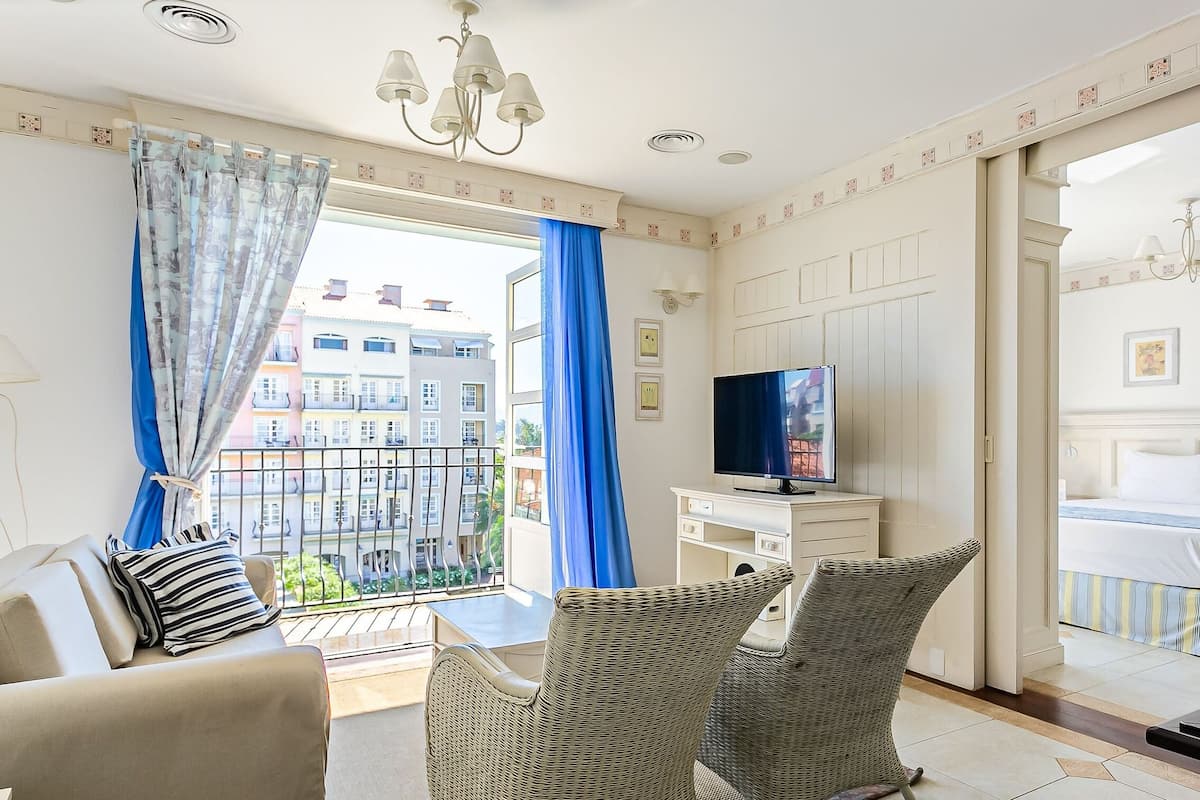 Una sala de estar moderna con balcón, televisión y cama.