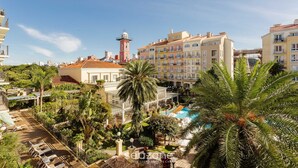 A hotel with a pool, palm trees, and a tower. - Studios frente ao mar no IL Campanario Resort ILCTOP (Florianópolis)