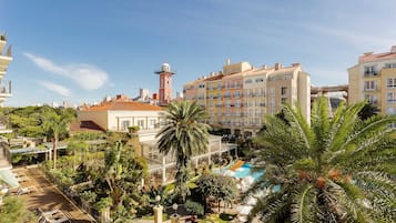 Un hotel con piscina, palmeras y una torre.