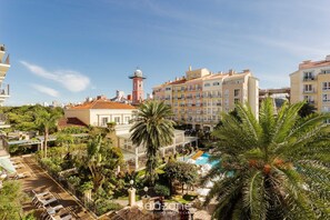 A hotel with a pool, palm trees, and a tower. - Studios frente ao mar no IL Campanario Resort ILCTOP (Florianópolis)