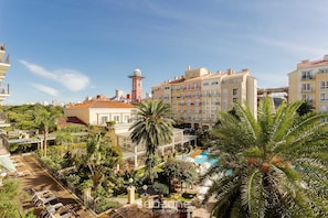Un hotel con piscina, palmeras y una torre.