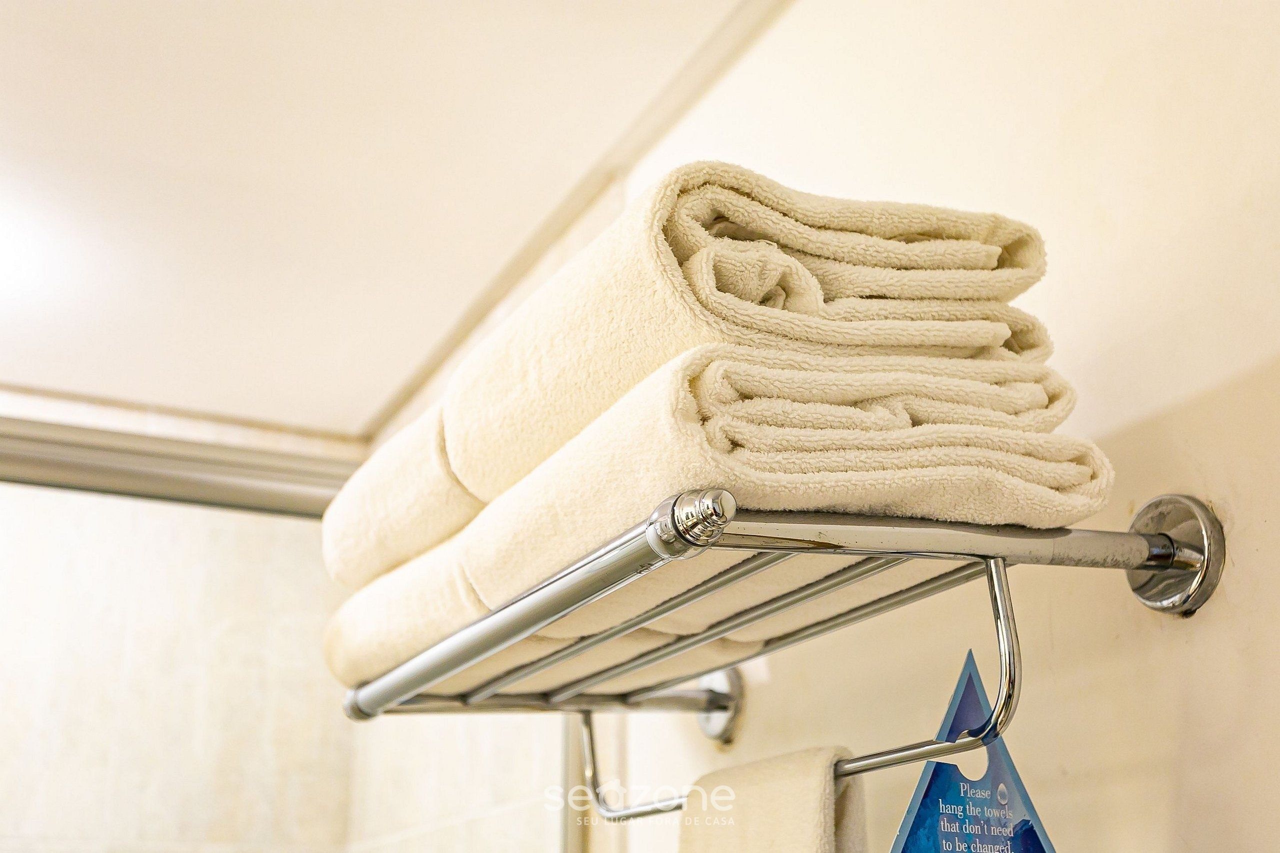 Un porte-serviettes en métal avec des serviettes pliées dans une salle de bain.