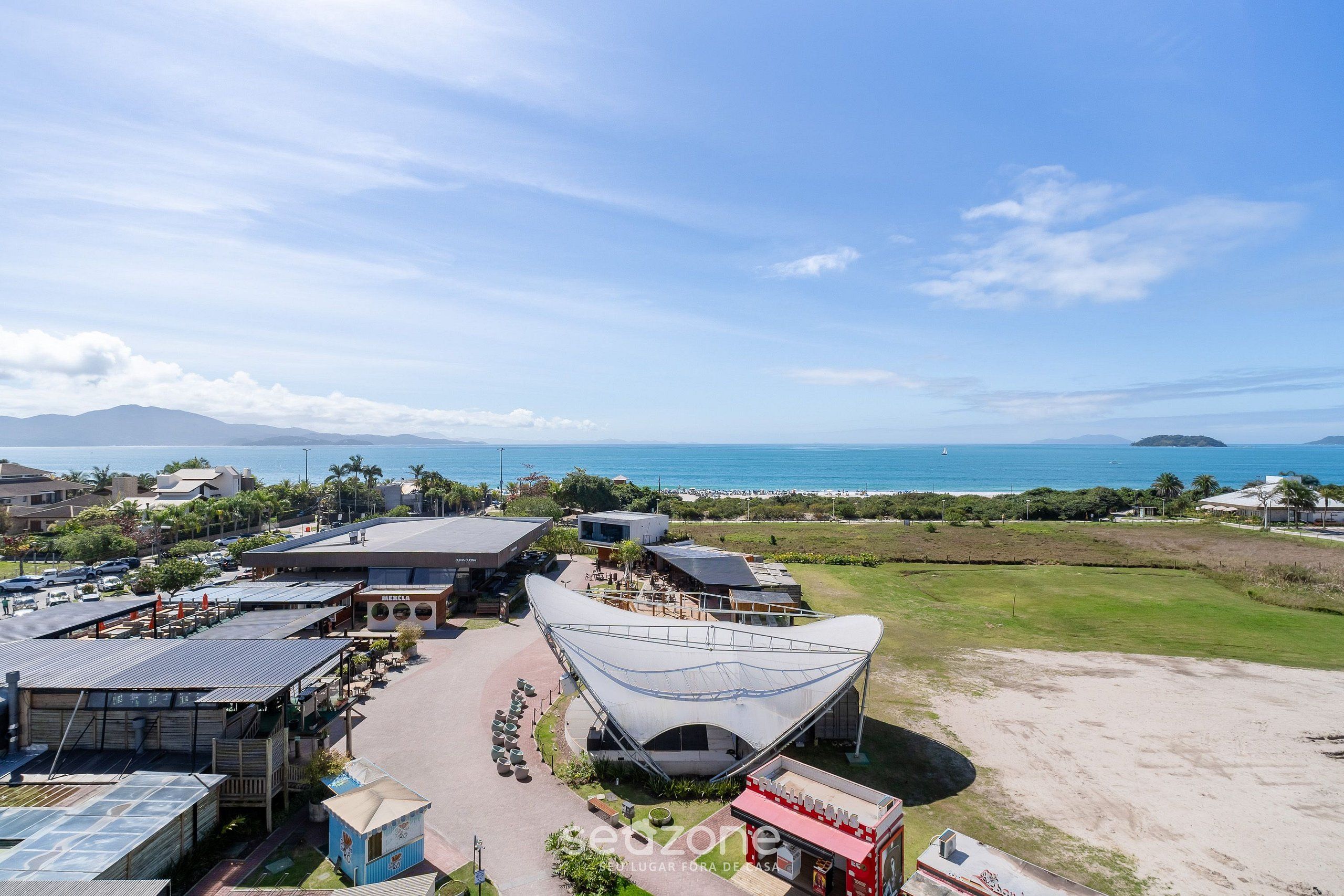 Vista aérea de un resort con un amplio espacio abierto, una playa y vistas al océano.