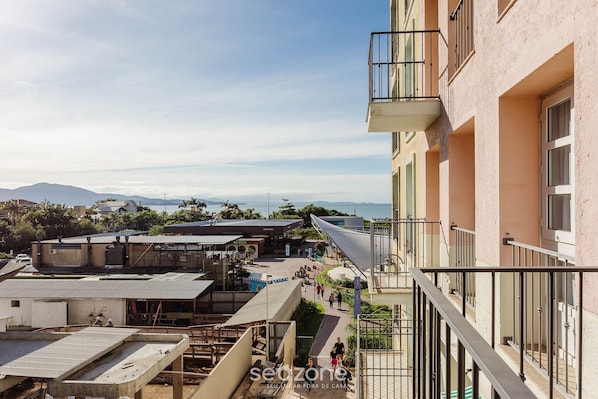 Un edificio residencial con balcones, una terraza en la azotea y vistas al mar y a las montañas.