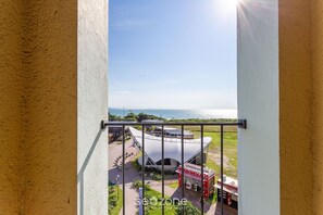 A view of a modern building with a unique architectural design, a balcony with a metal railing, and a clear sky. - Studios frente ao mar no IL Campanario Resort ILCTOP (Florianópolis)