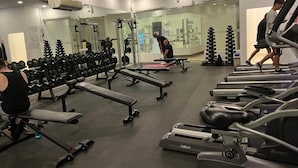 Ett gym med löpband, bänkar och styrketräningsmaskiner.