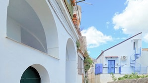 A narrow alleyway with white buildings, a green door, and a blue staircase. - Raito Guest House - Amalfi Coast (Vietri sul Mare)