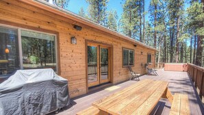 A wooden cabin with a deck, covered grill, and outdoor seating. - Enormous luxury cabin rental in unbeatable South Tahoe location (South Lake Tahoe)