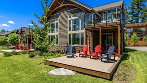A modern house with a deck, large windows, and outdoor seating. - 3 + bed 2 bath Villa on Lake Muskoka (Bracebridge)
