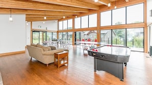 A spacious indoor area with a pool table, a sofa, and a dining table.