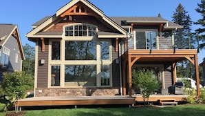 A two-story house with a large front porch, stone foundation, and a covered deck area. - 4 bed 4 bath Villa on Lake Muskoka (Port Carling)