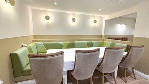 A dining area with a green booth seating and a white table. - Breckland Thatched Cottage: Hot Tub, 8 Cozy Rooms, Spacious Lounge (Hockwold cum Wilton)
