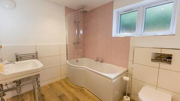 Ein Badezimmer mit Dusche, Waschbecken und Toilette.