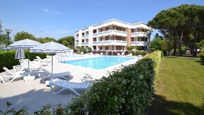 Un hôtel doté d’une piscine, de chaises longues et de parasols.