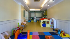 A children's playroom with a playhouse, toys, and a soft play area. - Coberturas sofisticadas no IL Campanario Resort ILCTOPM (Florianópolis)